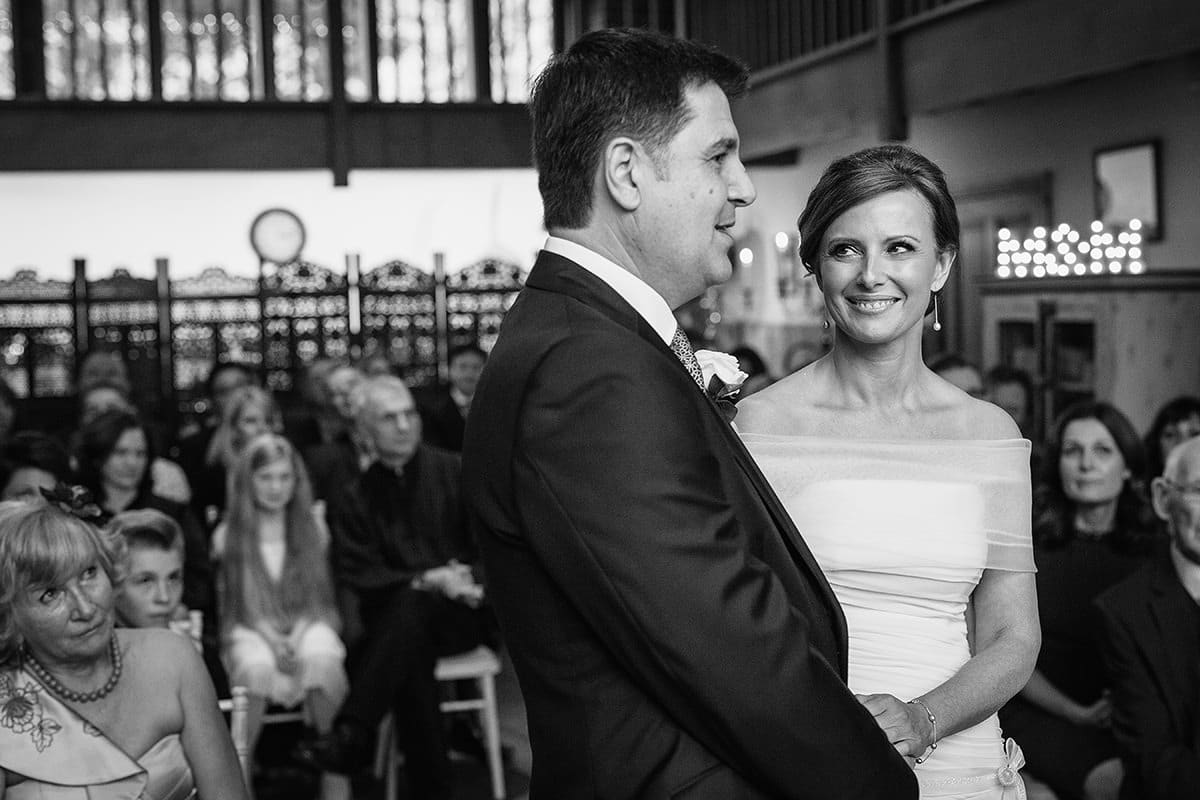 the bride smiles at the groom during their wedding ceremony