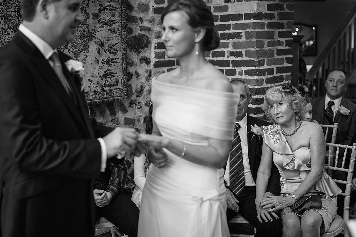 the groom places the brides ring on her finger
