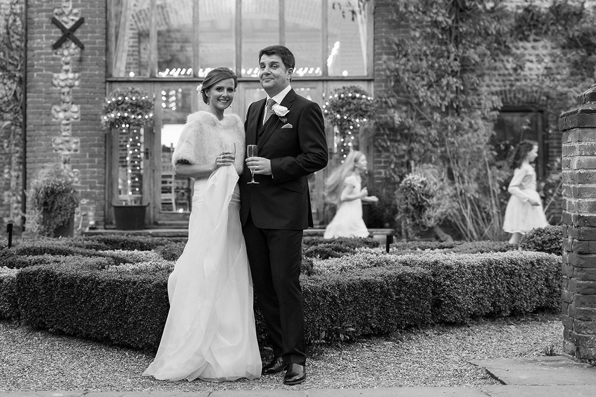 the bride and groom pose outside chaucer barn