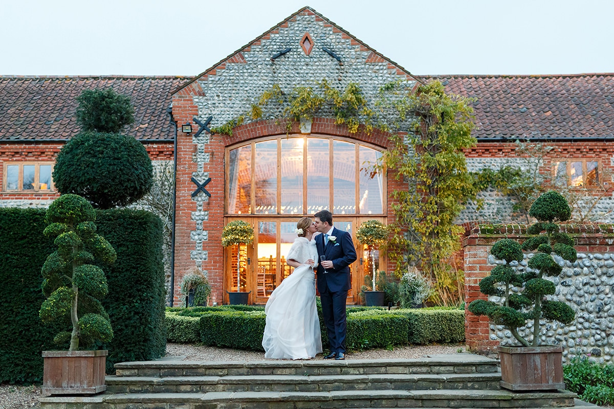 the bride and groom kiss outside chaucer barn