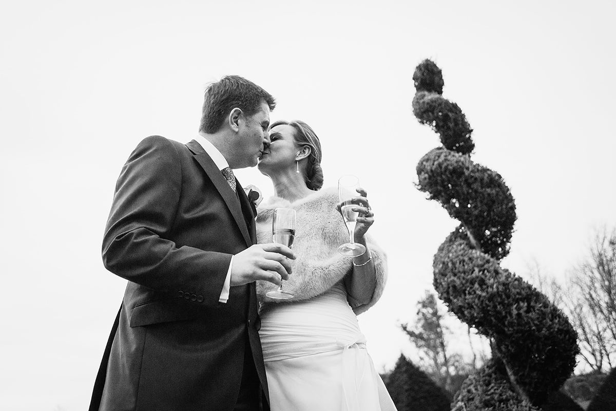 the bride and groom kiss in the gardens of chaucer barn