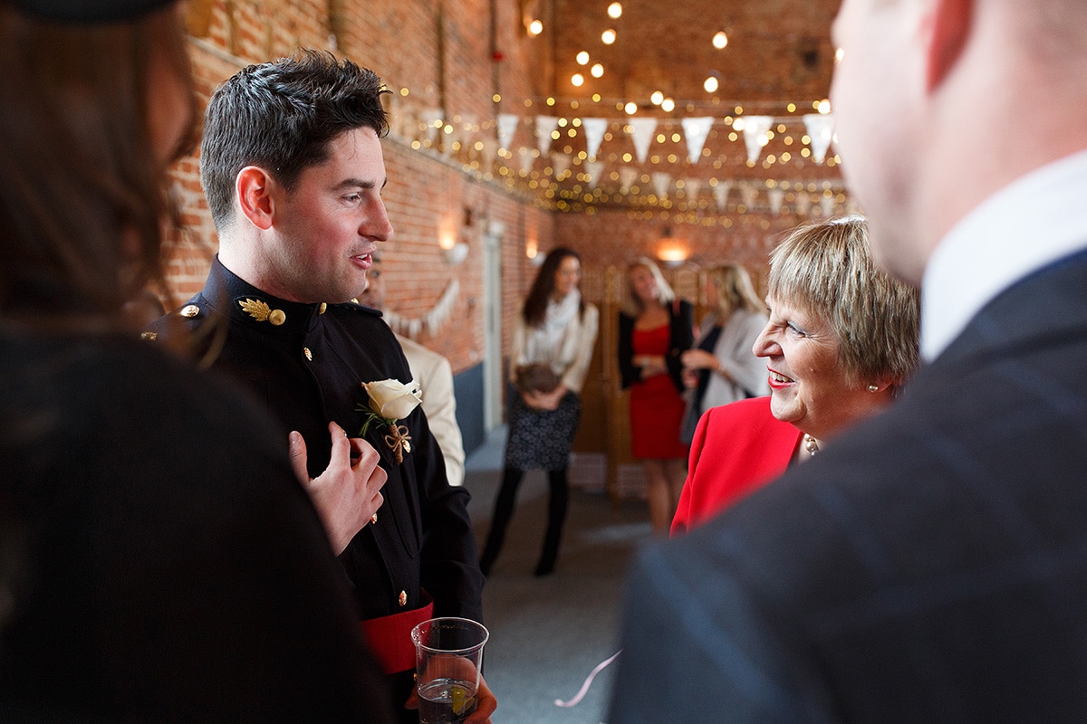 the groom talking to his guests in godwick barn