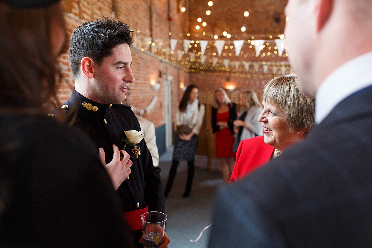 the groom talking to his guests in godwick barn