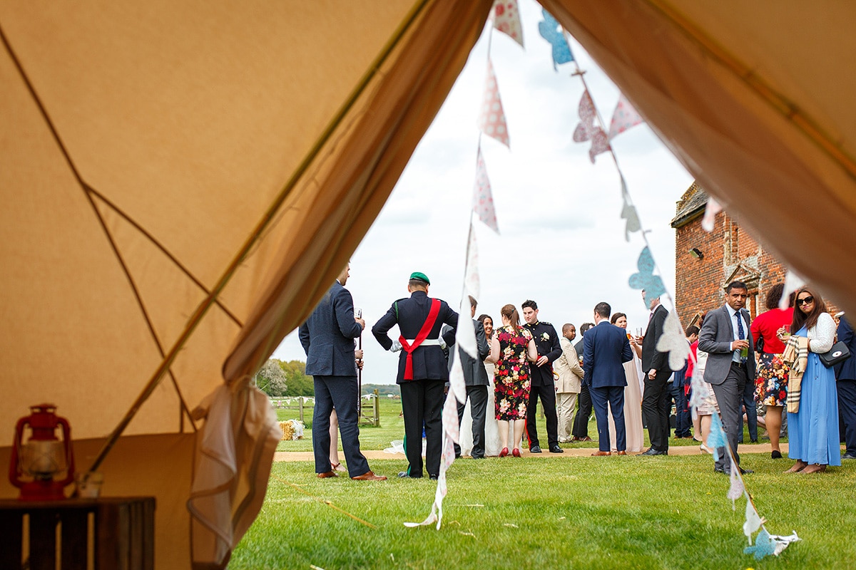 wedding guests viewed from inside the bell tent