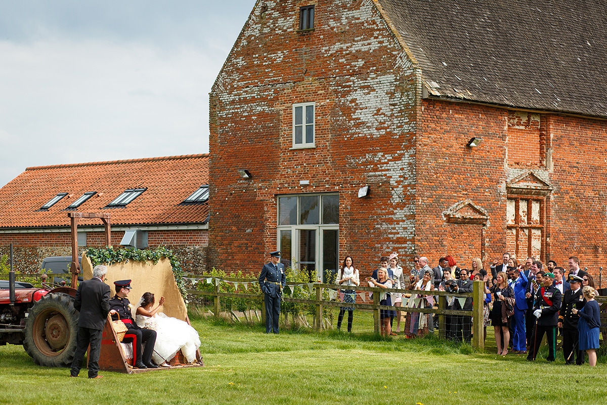 guests wave them goodbye as they board the godwick tractor