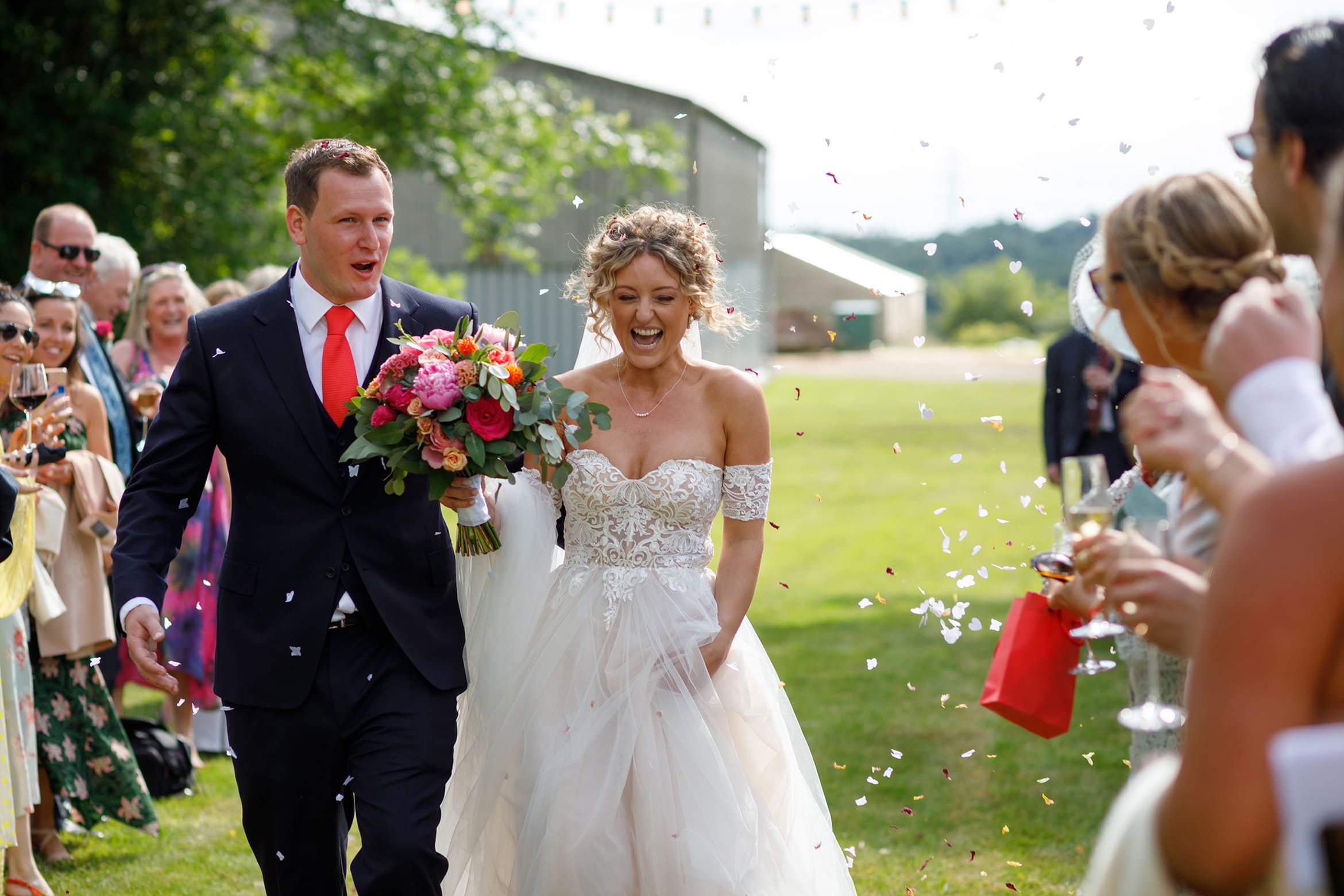 bride and groom walk through the confetti