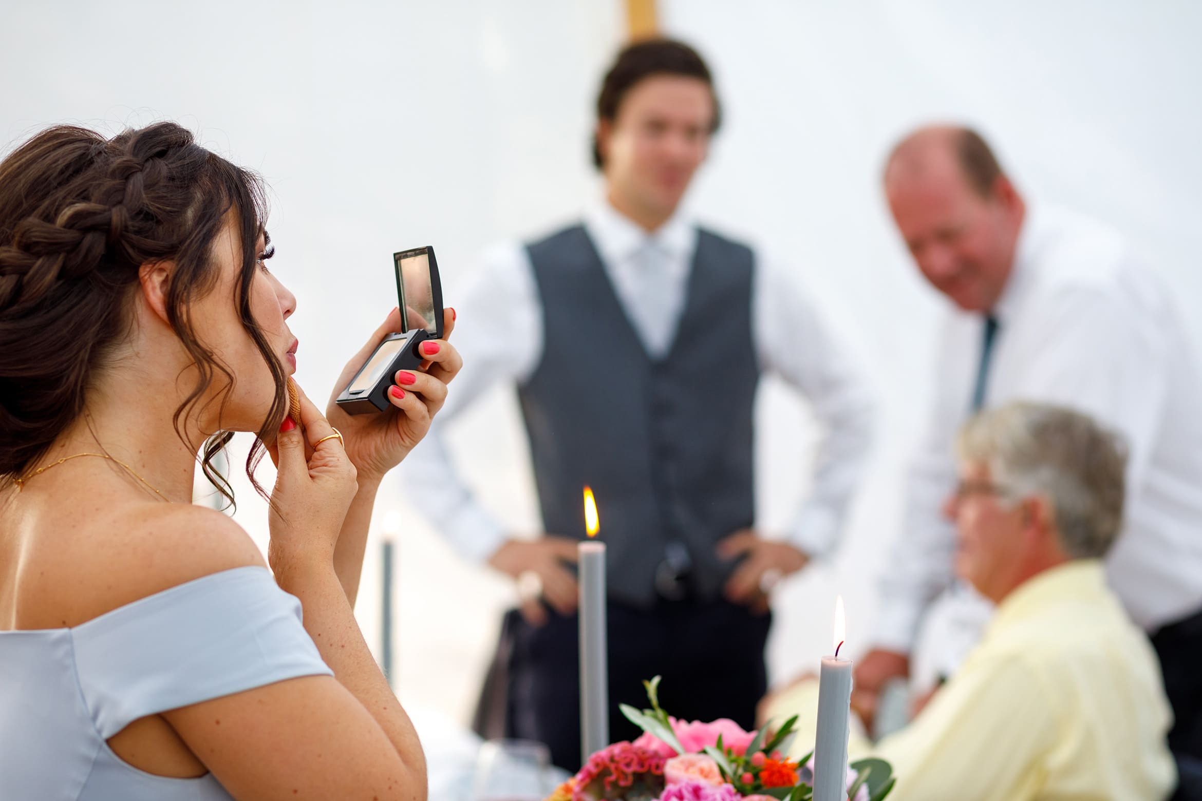 a bridesmaid touches up her makeup