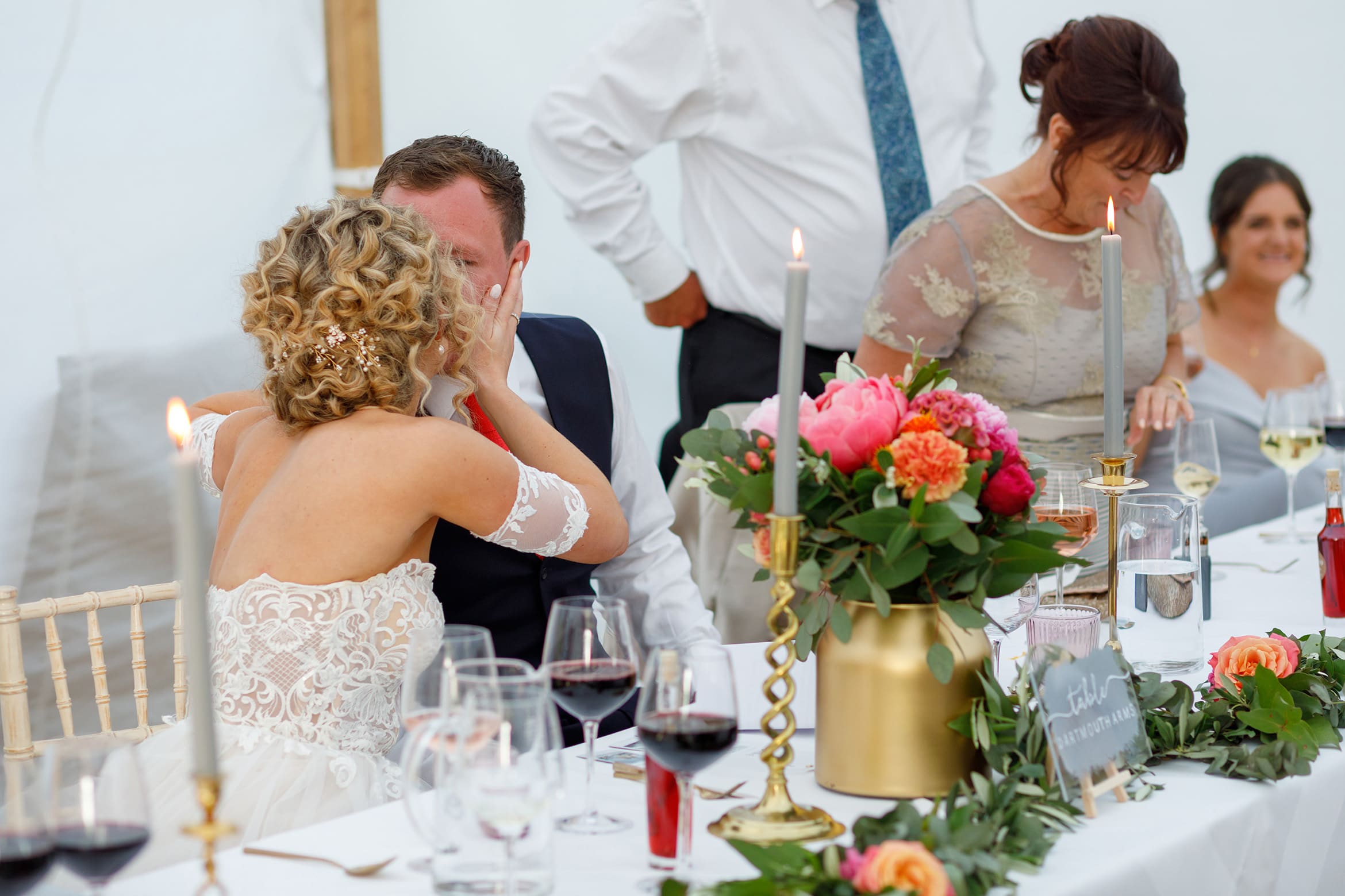 bride and groom kiss at the top table