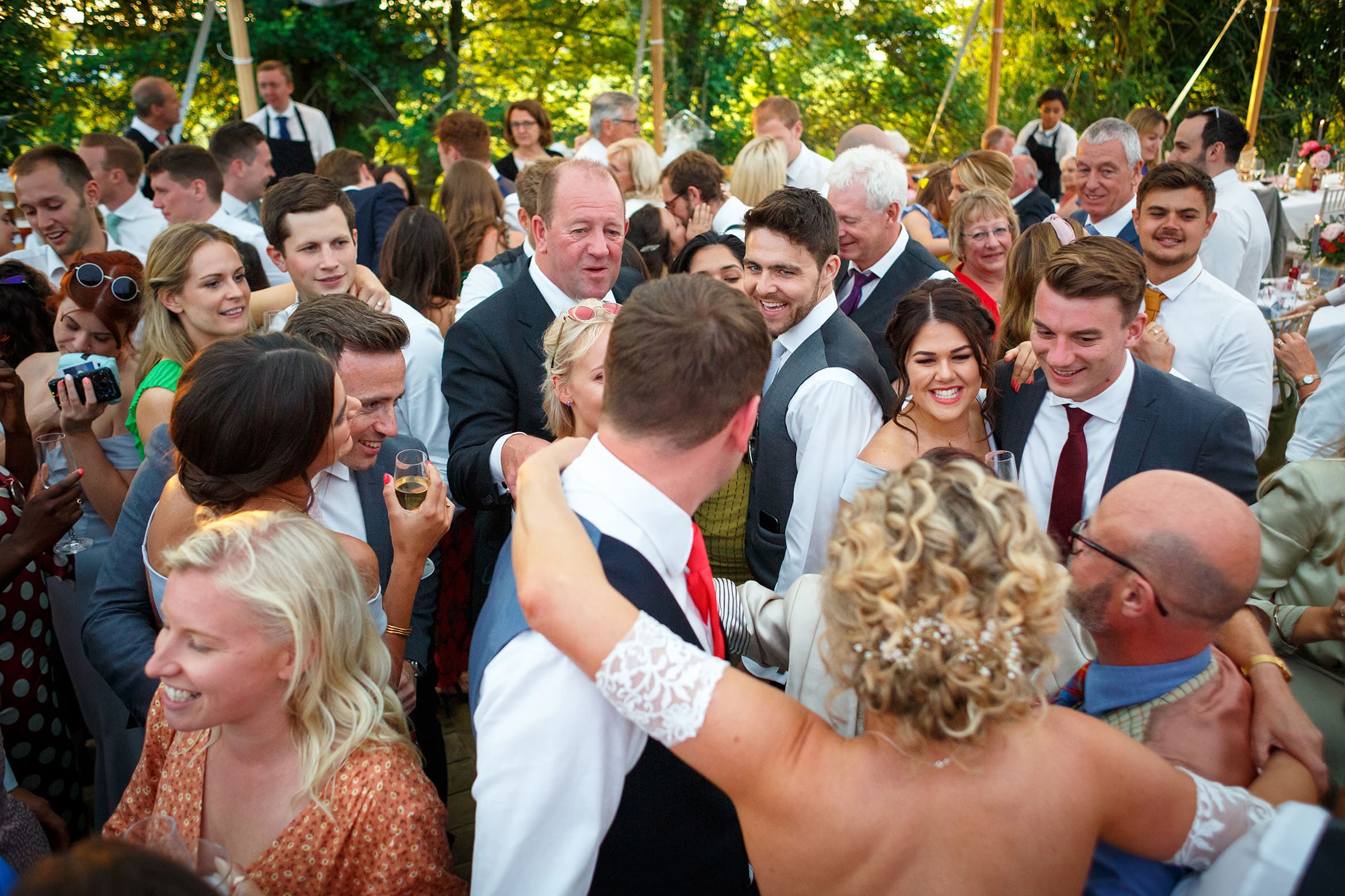 wedding guests smiling at the bride and groom on the dancefloor