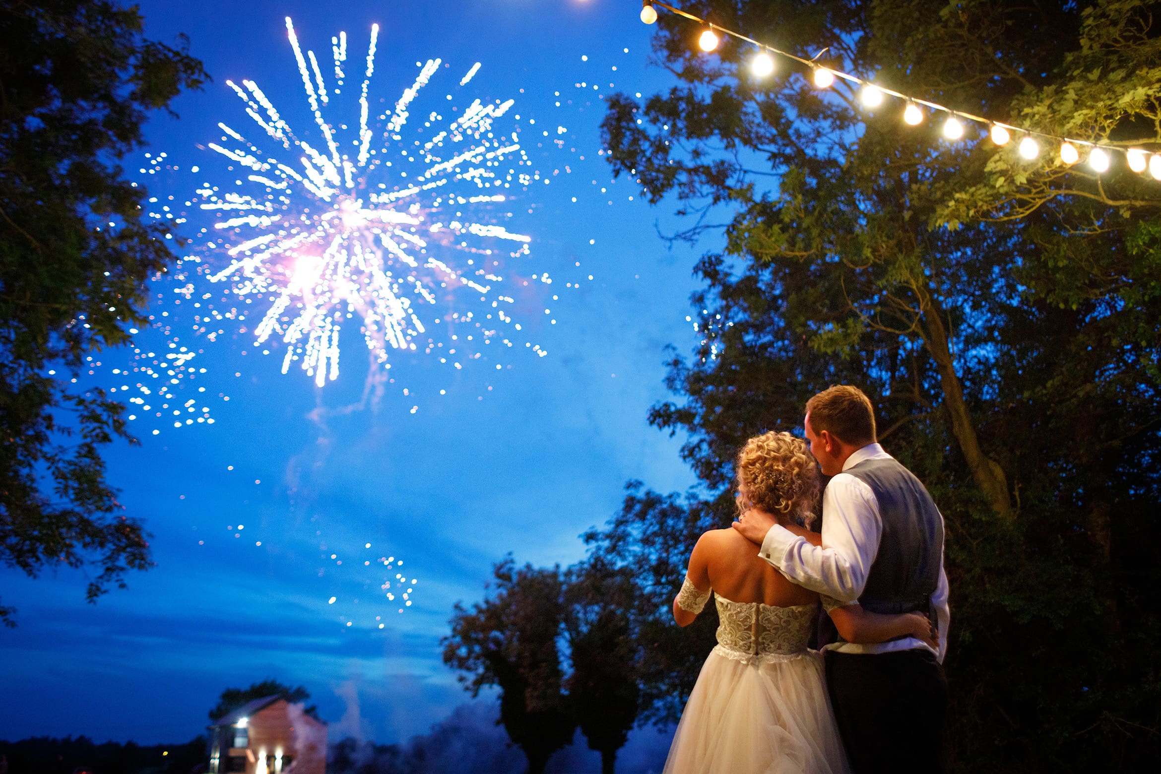 bride and groom watch their wedding fireworks