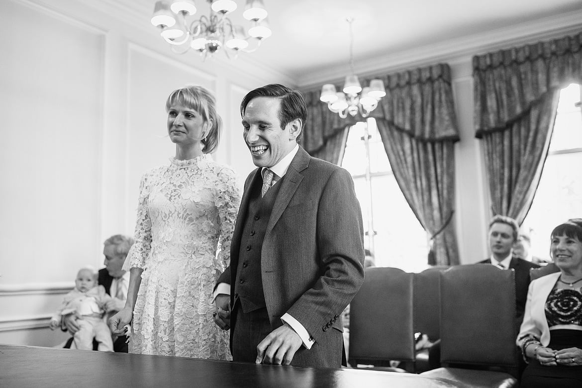 bride and groom share a joke during the ceremony