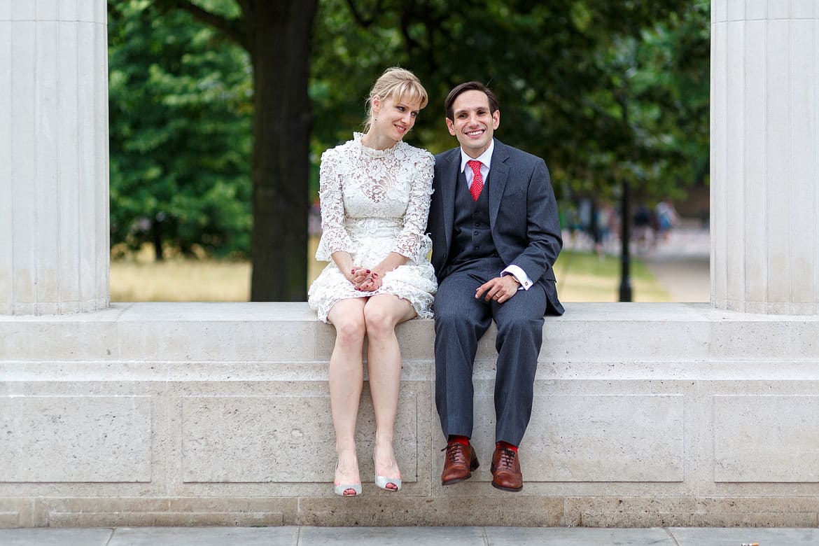 the happy couple sitting on a wall