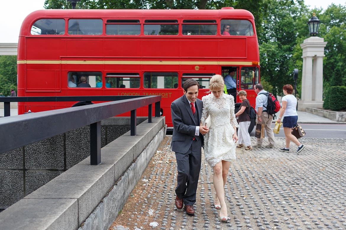david and rowena walk through london with a routemaster bus in the background