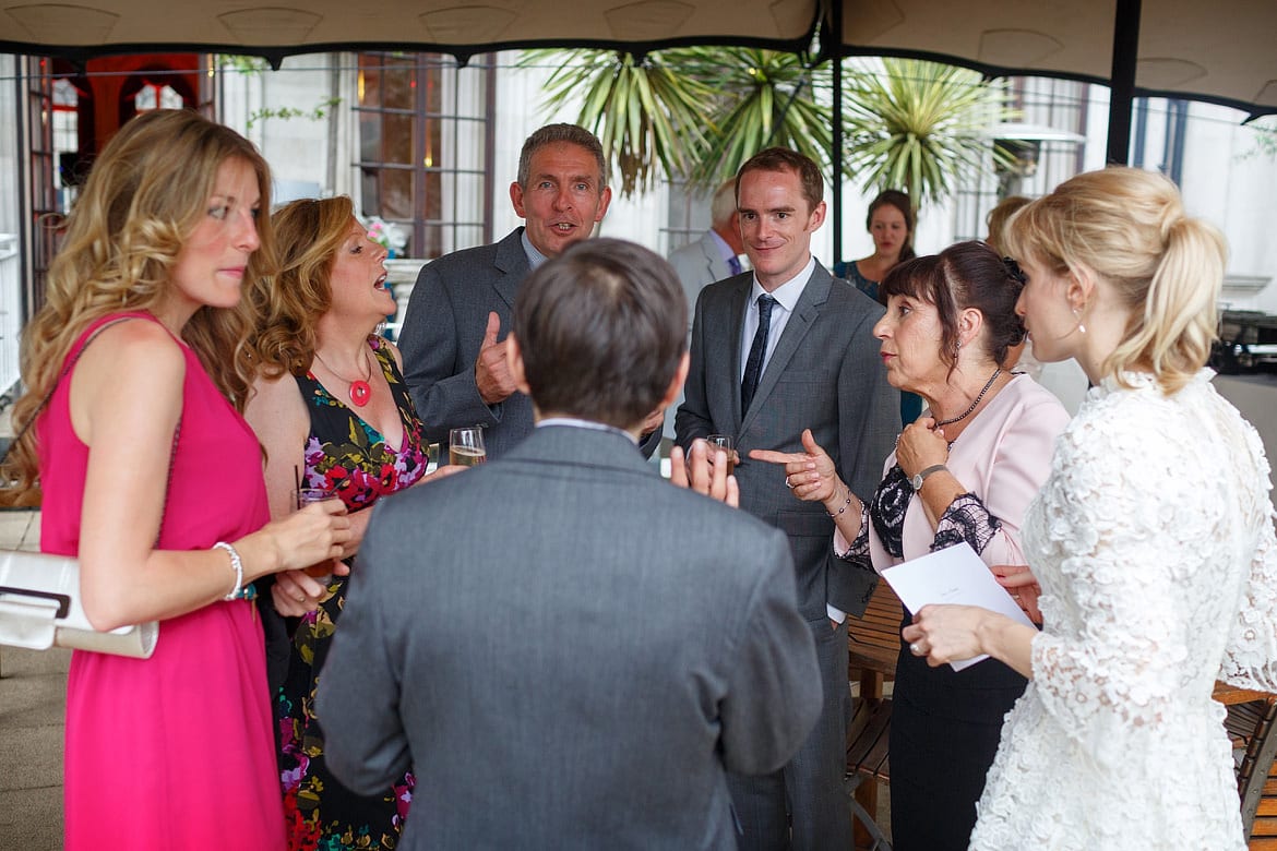 the groom chats with the guests outside