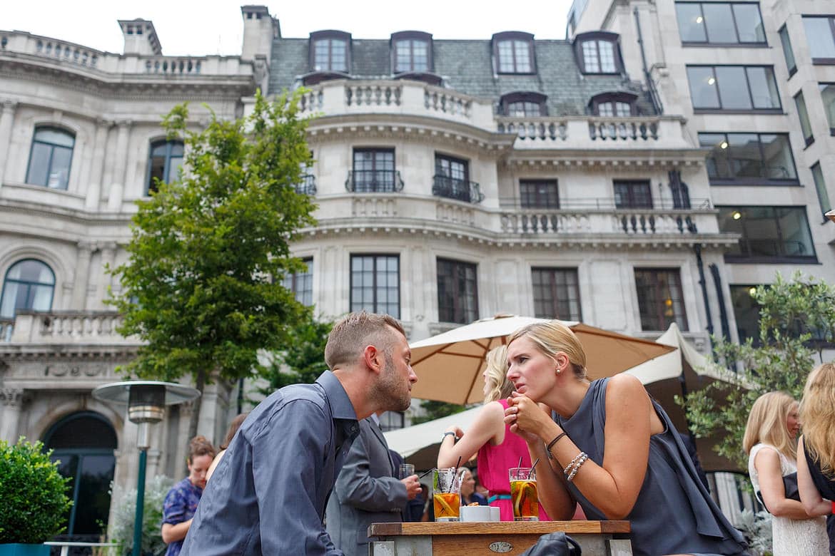 wedding guests talking with the royal aeronautical society building in the background