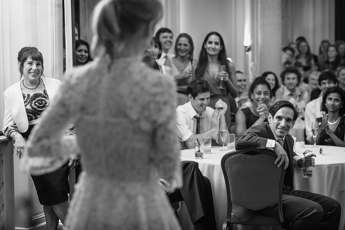 the groom smiling at the brides speech
