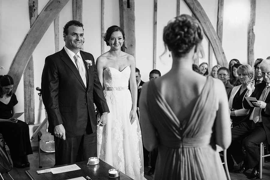 bride and groom listen to a reading