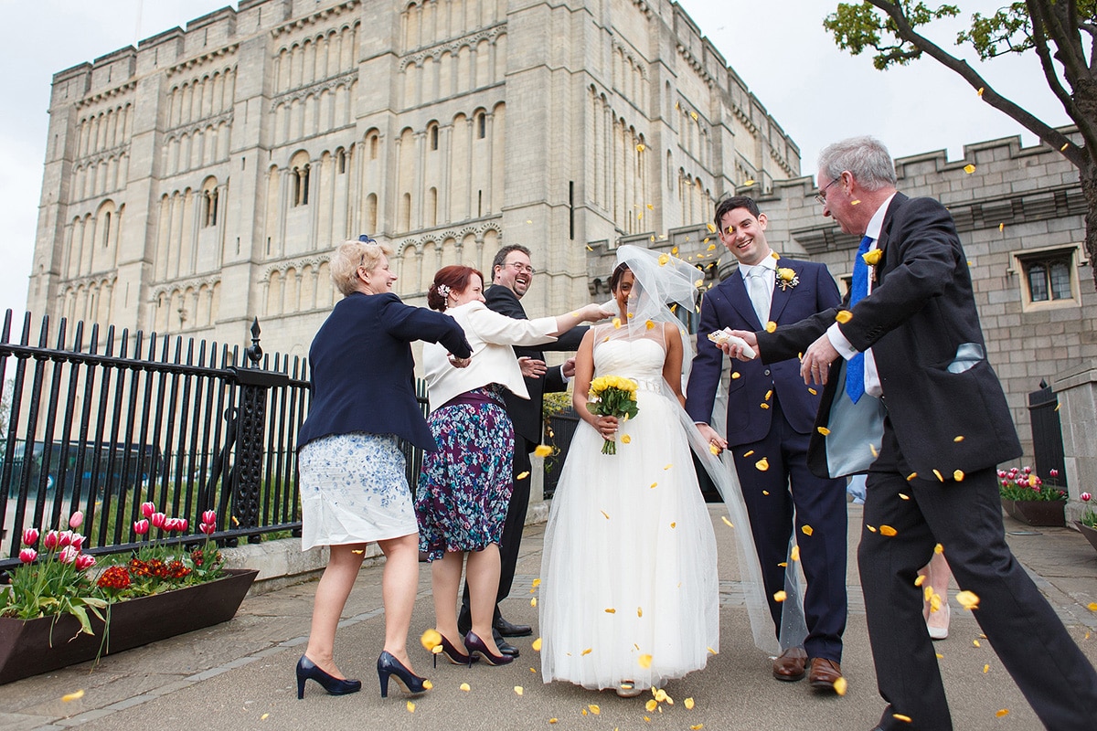 guests throw confetti over the couple outside norwich castle