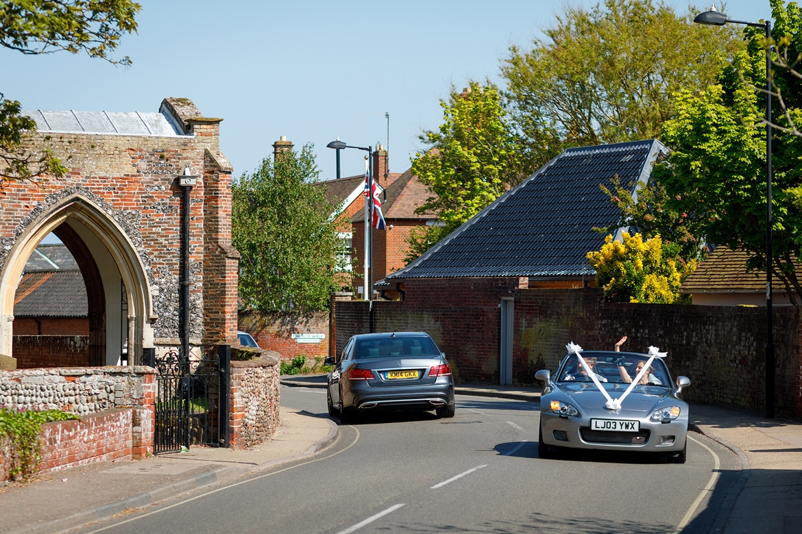 the bride arrives at aldeburgh church in her dads sportscar