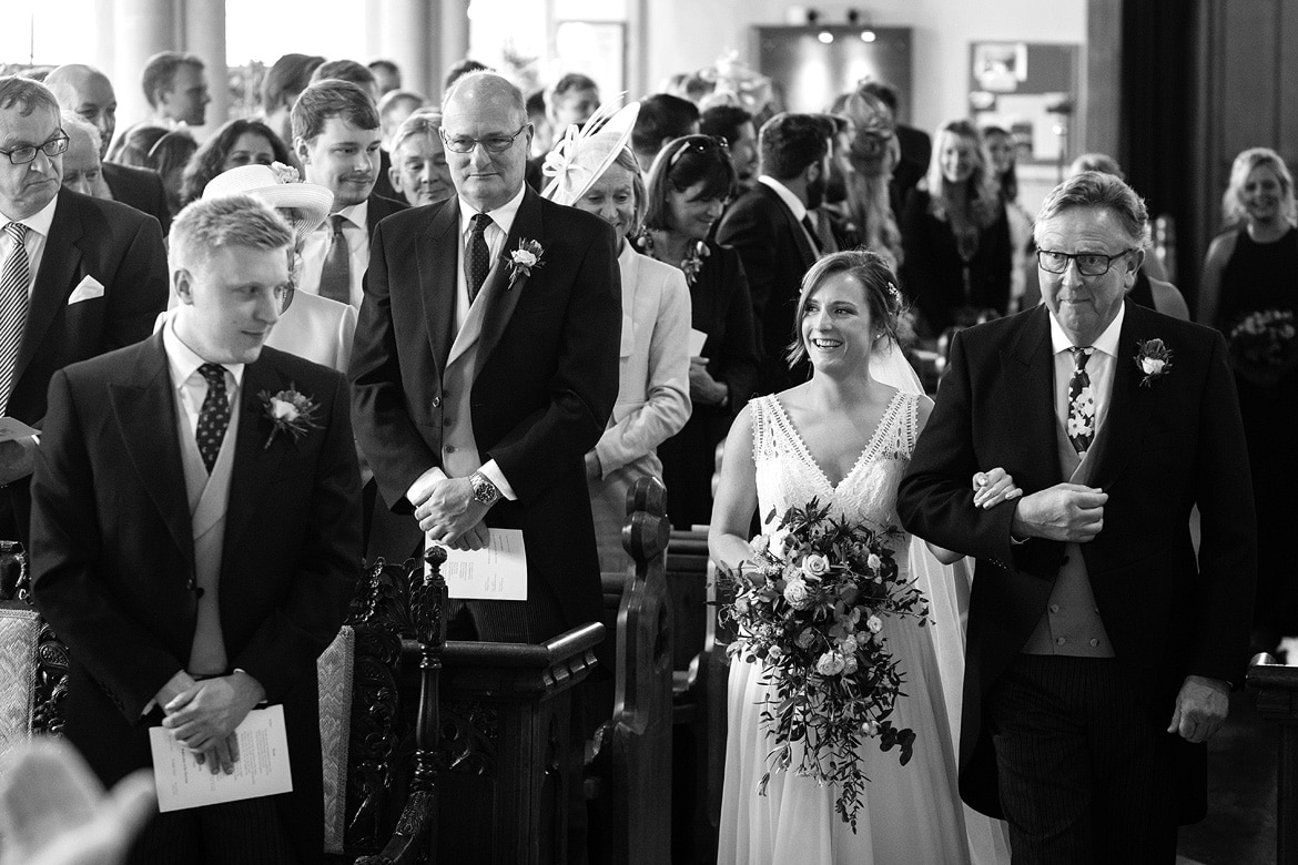 bride and her father walk down the aisle of aldeburgh church