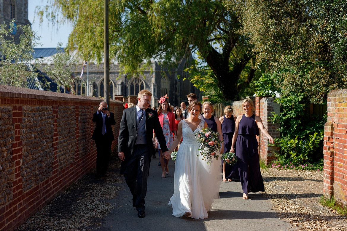 the wedding party walks through aldeburgh