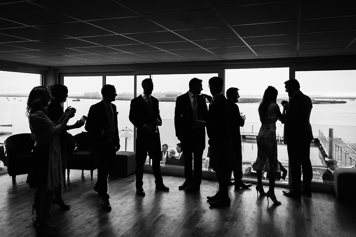 wedding guests silhouetted against the river