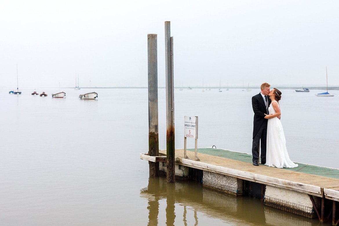 bride and groom on the jetty at their aldeburgh yacht club wedding