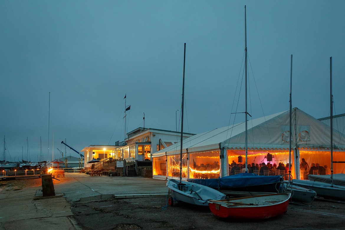 aldeburgh yacht club as night falls on the wedding marquee