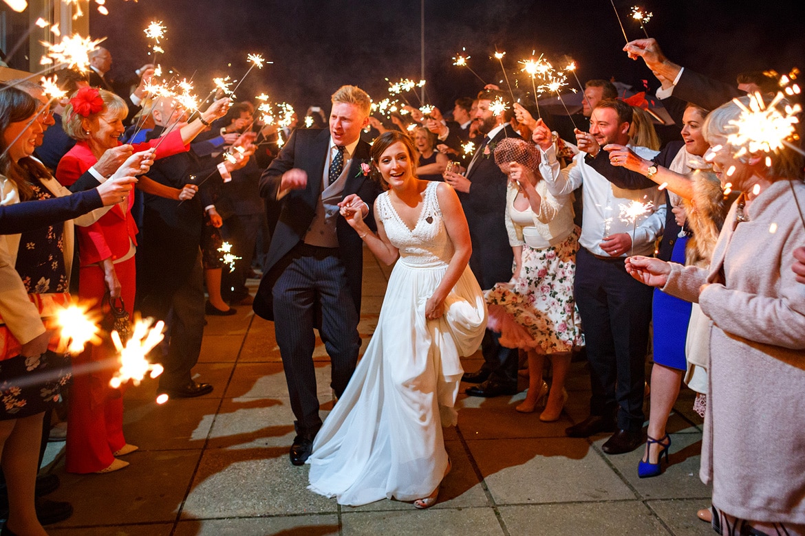 bride and groom run through the sparklers at their aldeburgh yacht club wedding