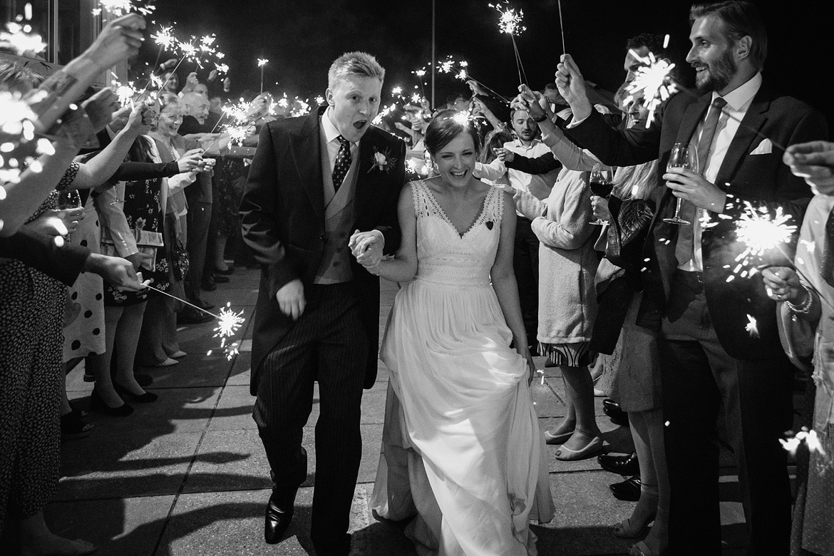 bride and groom run through the sparklers