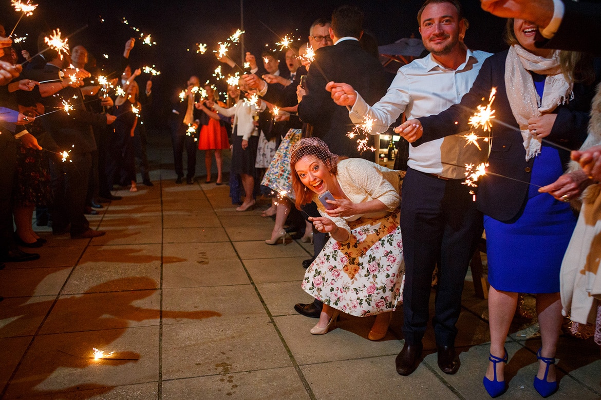 bride and groom run through the sparklers