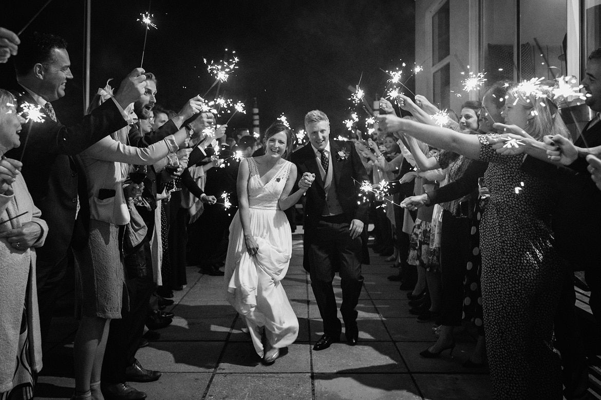 bride and groom run through the sparklers