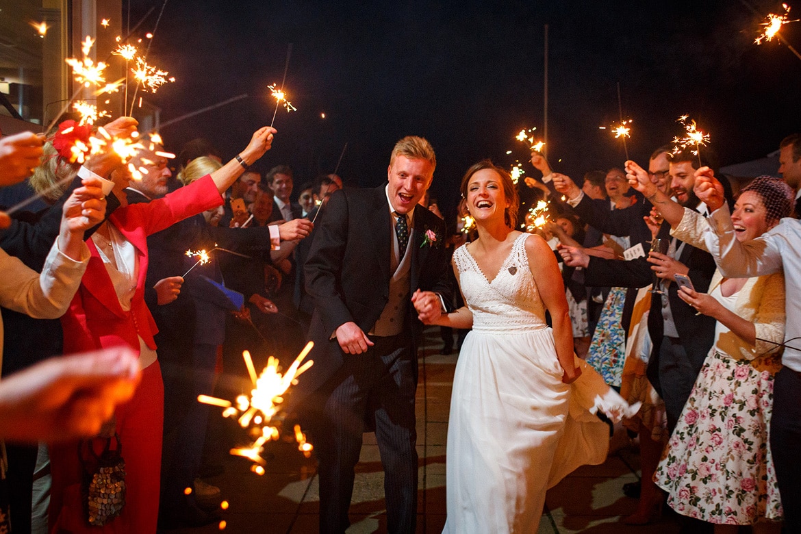 bride and groom run through the sparklers