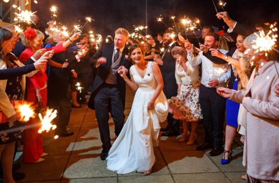 bride and groom run through sparklers at their aldeburgh yacht club wedding