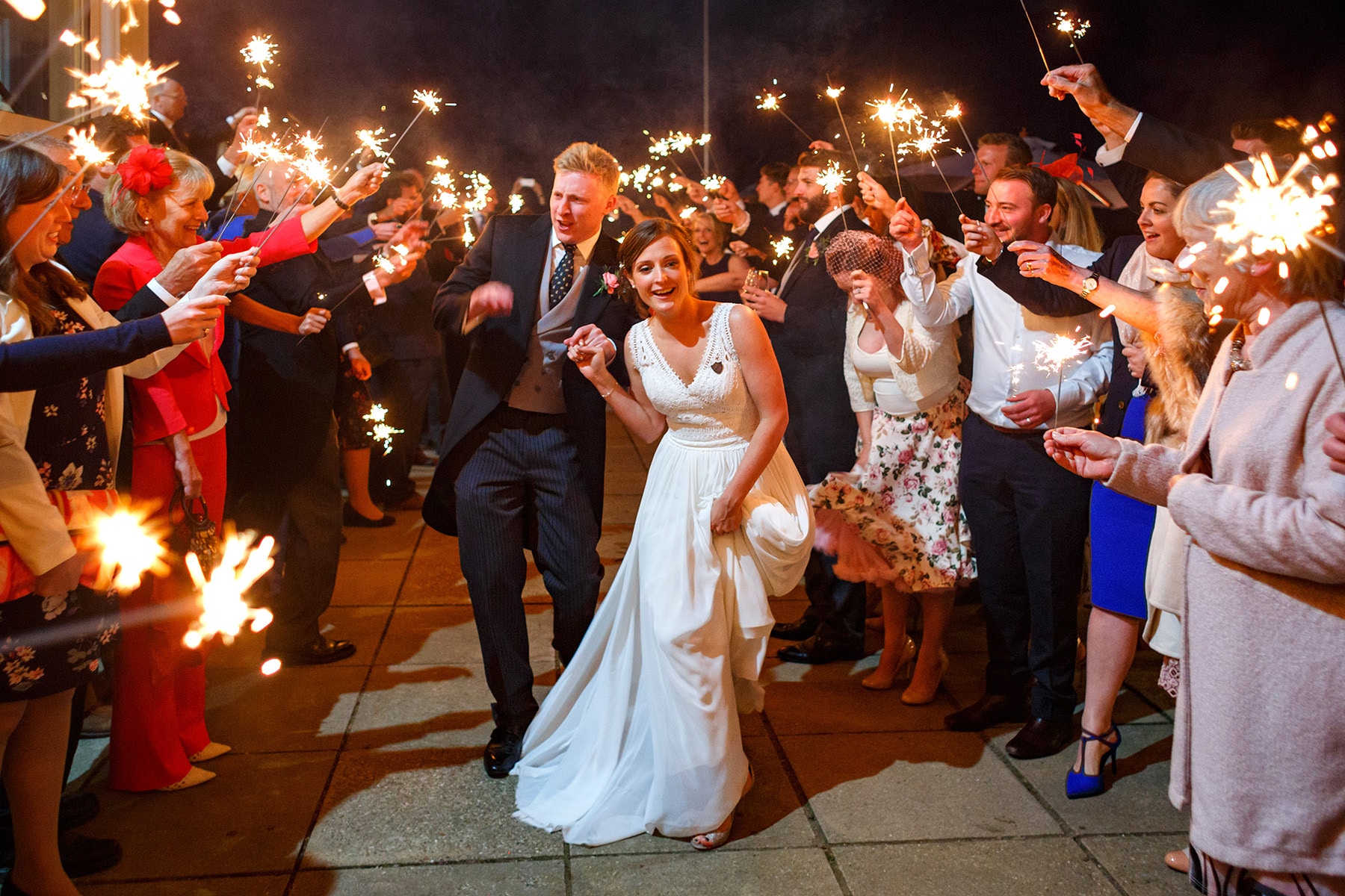 bride and groom run through sparklers at their aldeburgh yacht club wedding