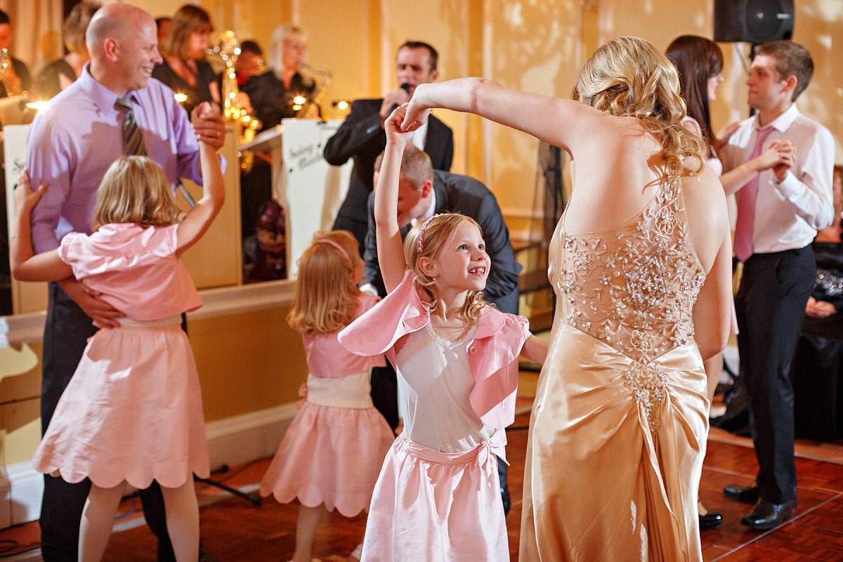 a flowergirl dances with the bride