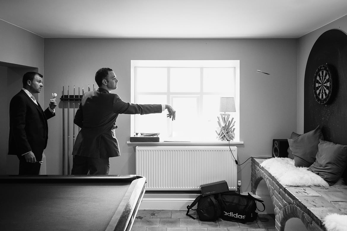 the groomsmen play darts before a godwick barn wedding