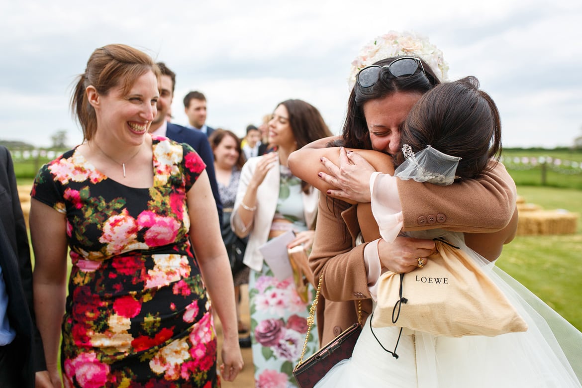 a wedding guest hugging the bride