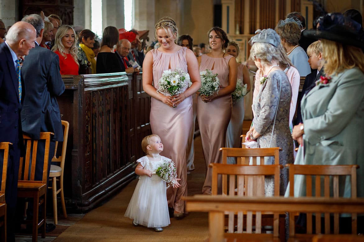 a flower girl walks the aisle at a suffolk wedding