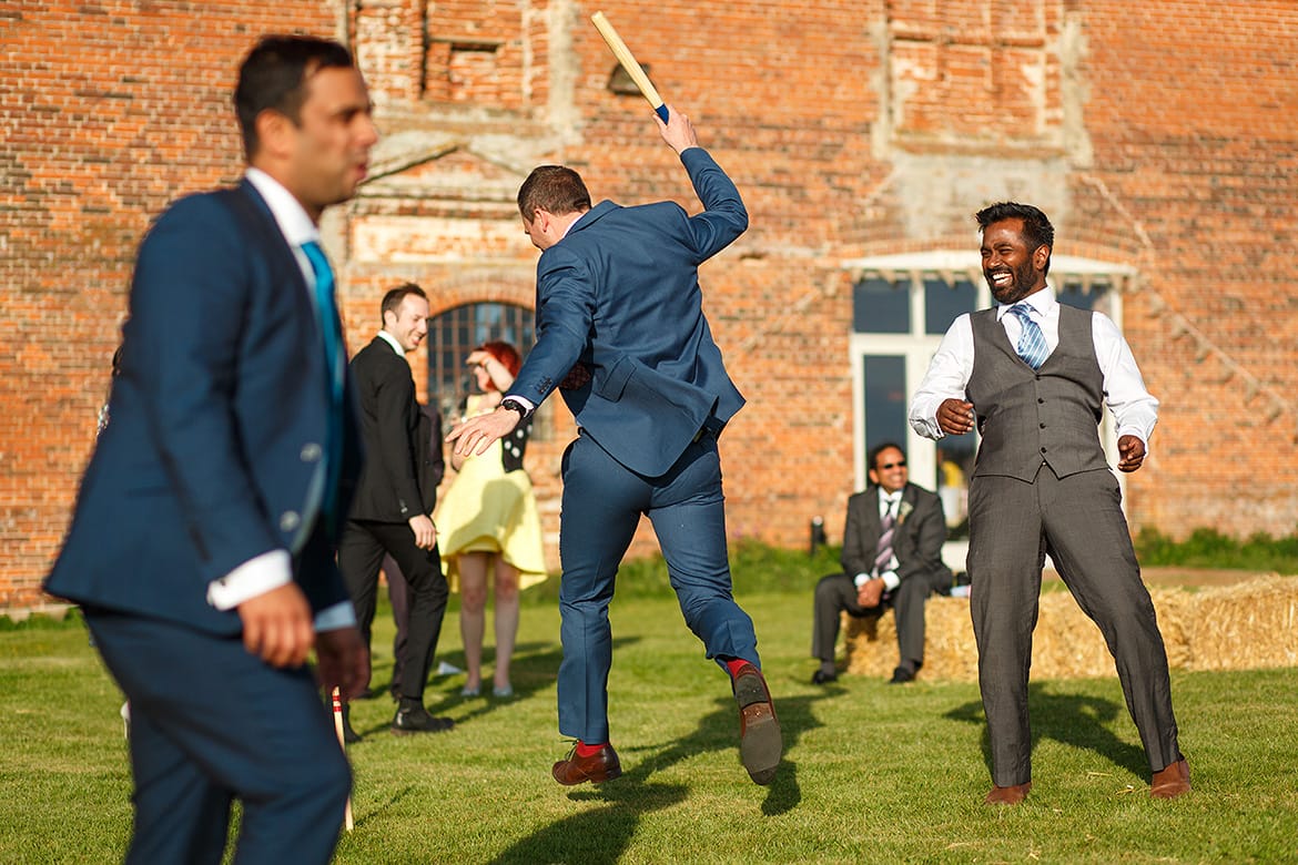 guests play rounders outside the wedding barn