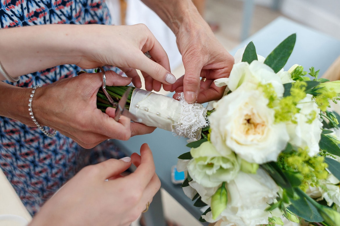 the brides mother helps her with her bouquet