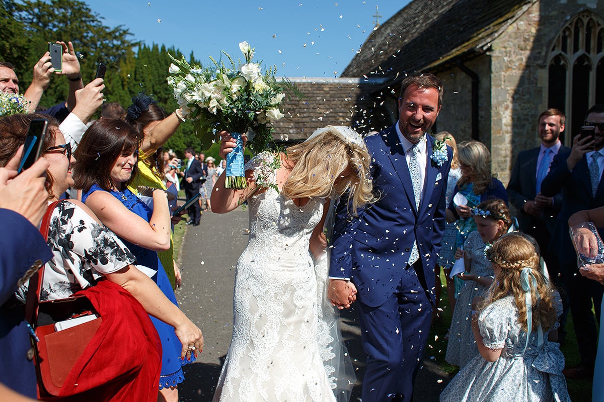 laura and todd walk through the confetti