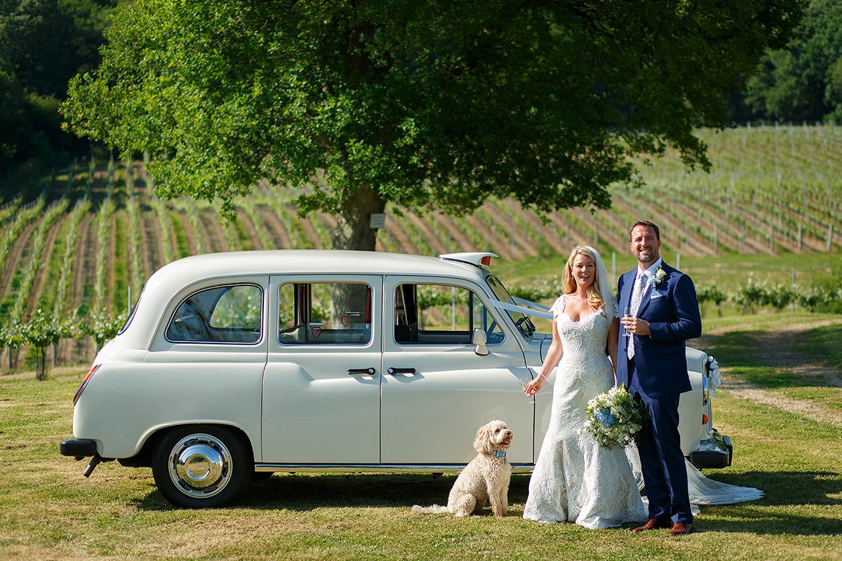 laura and todd pose with their dog and the taxi