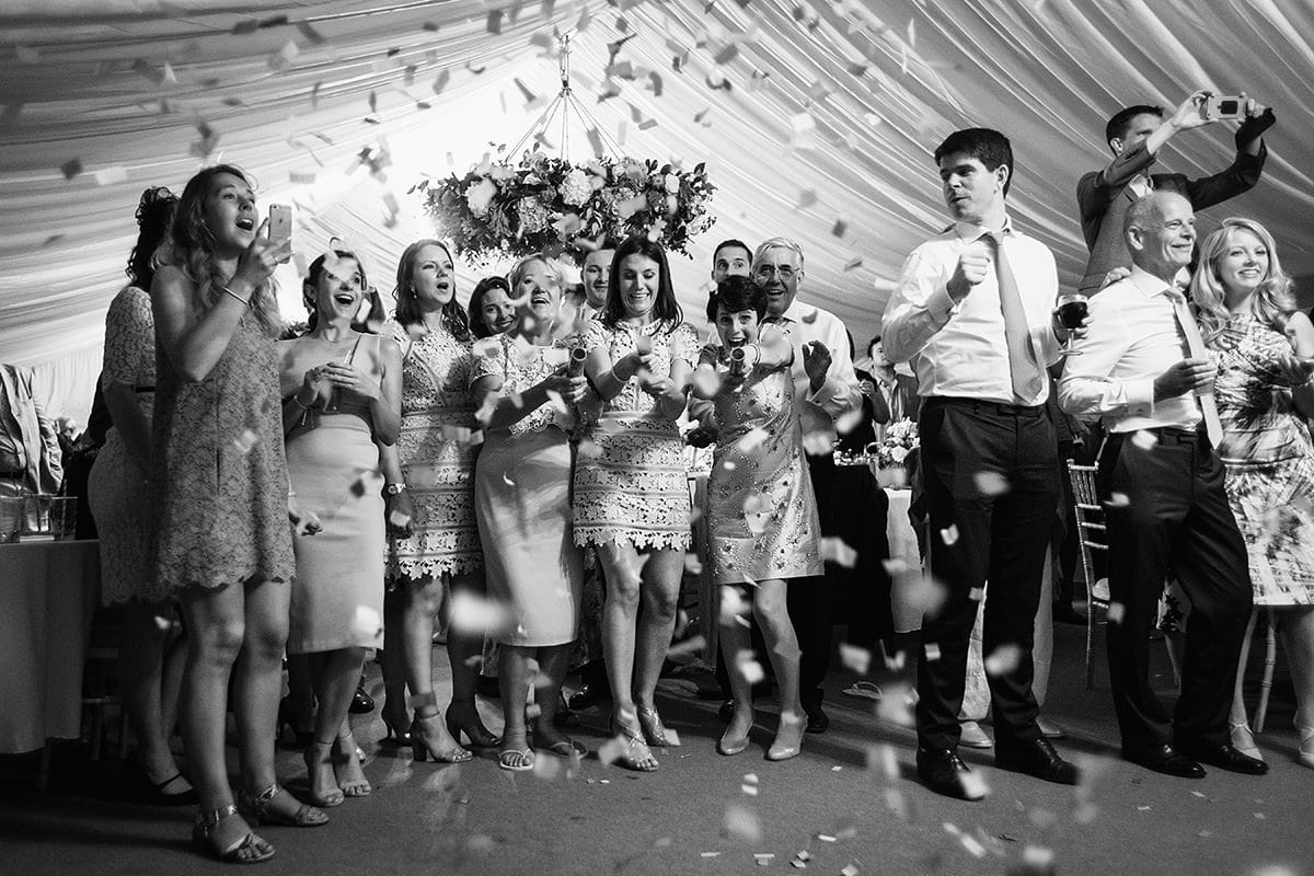 bridesmaids fire confetti cannons during the first dance