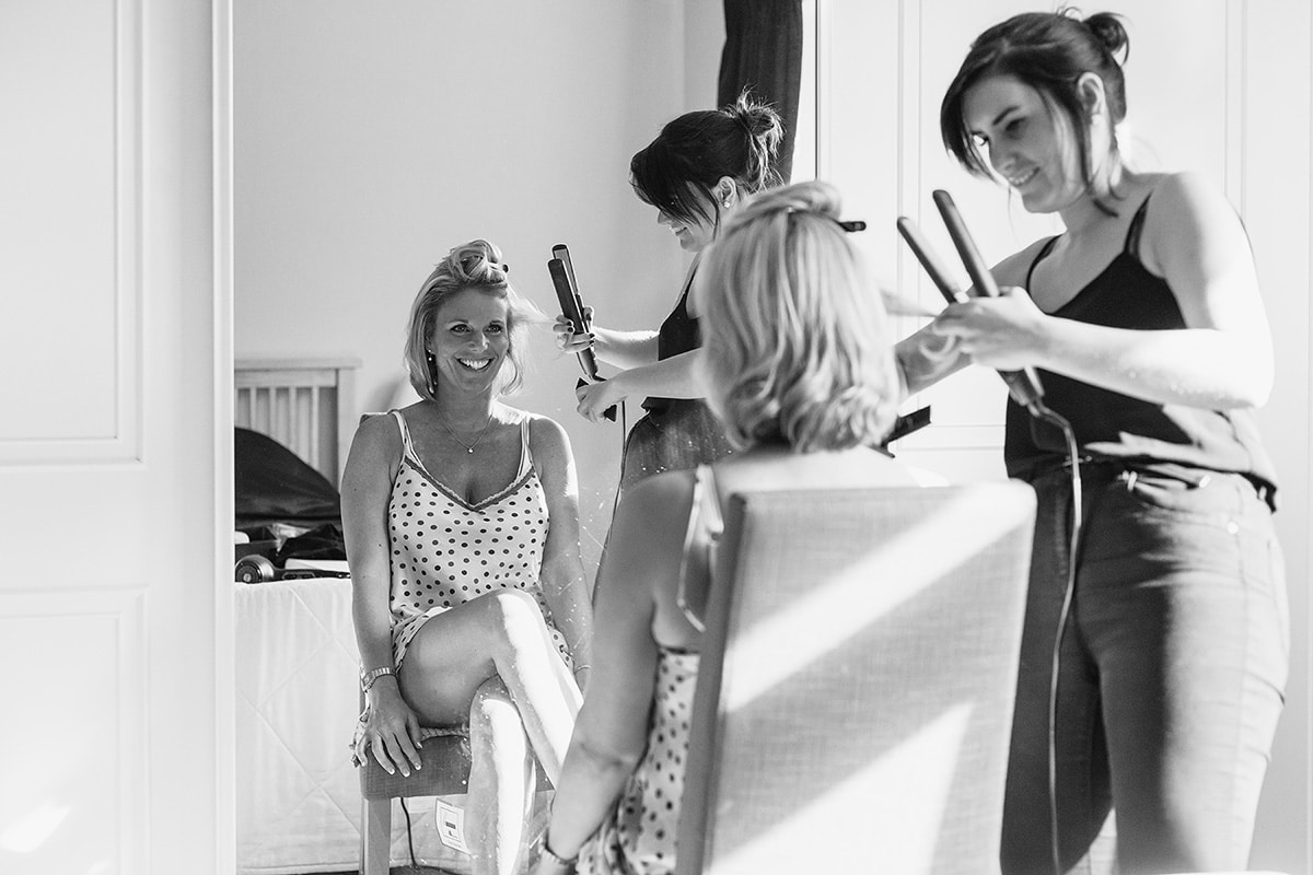 the bride has the finishing touches applied to her hair