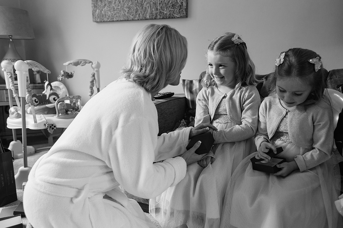 the bride enjoys a moment with the flower girls