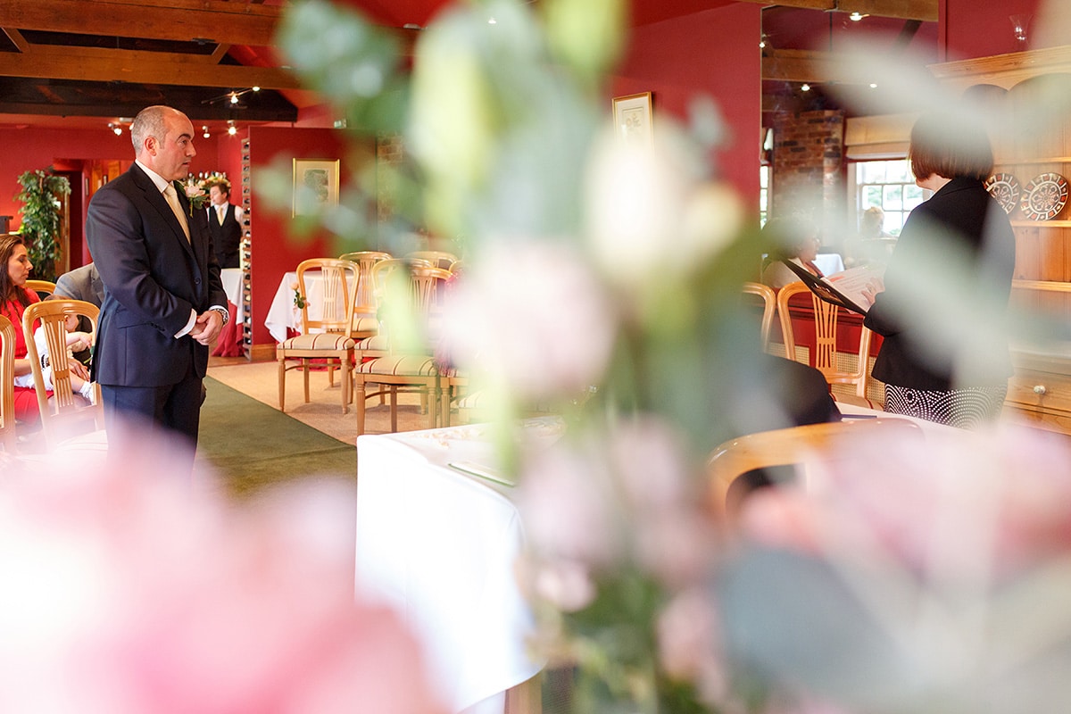 the groom waits at the end of the aisle