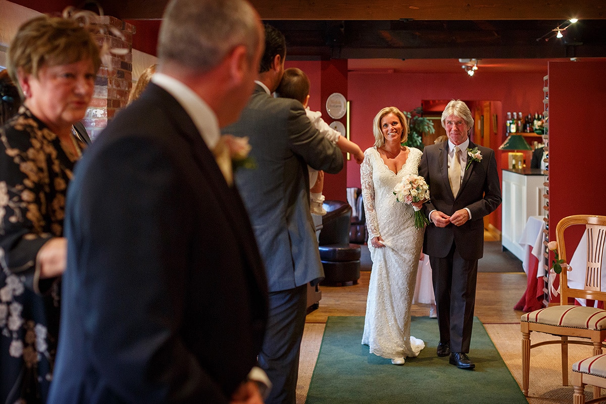 the bride and her father walk down the aisle at brasteds