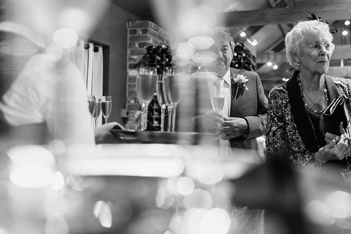 the father of the groom seen through some champagne glasses