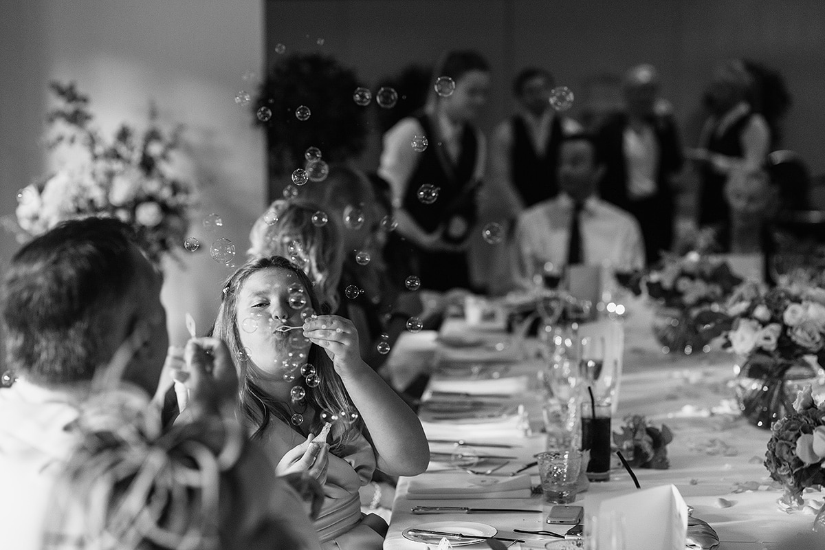 wedding guests blowing bubbles at the dining table